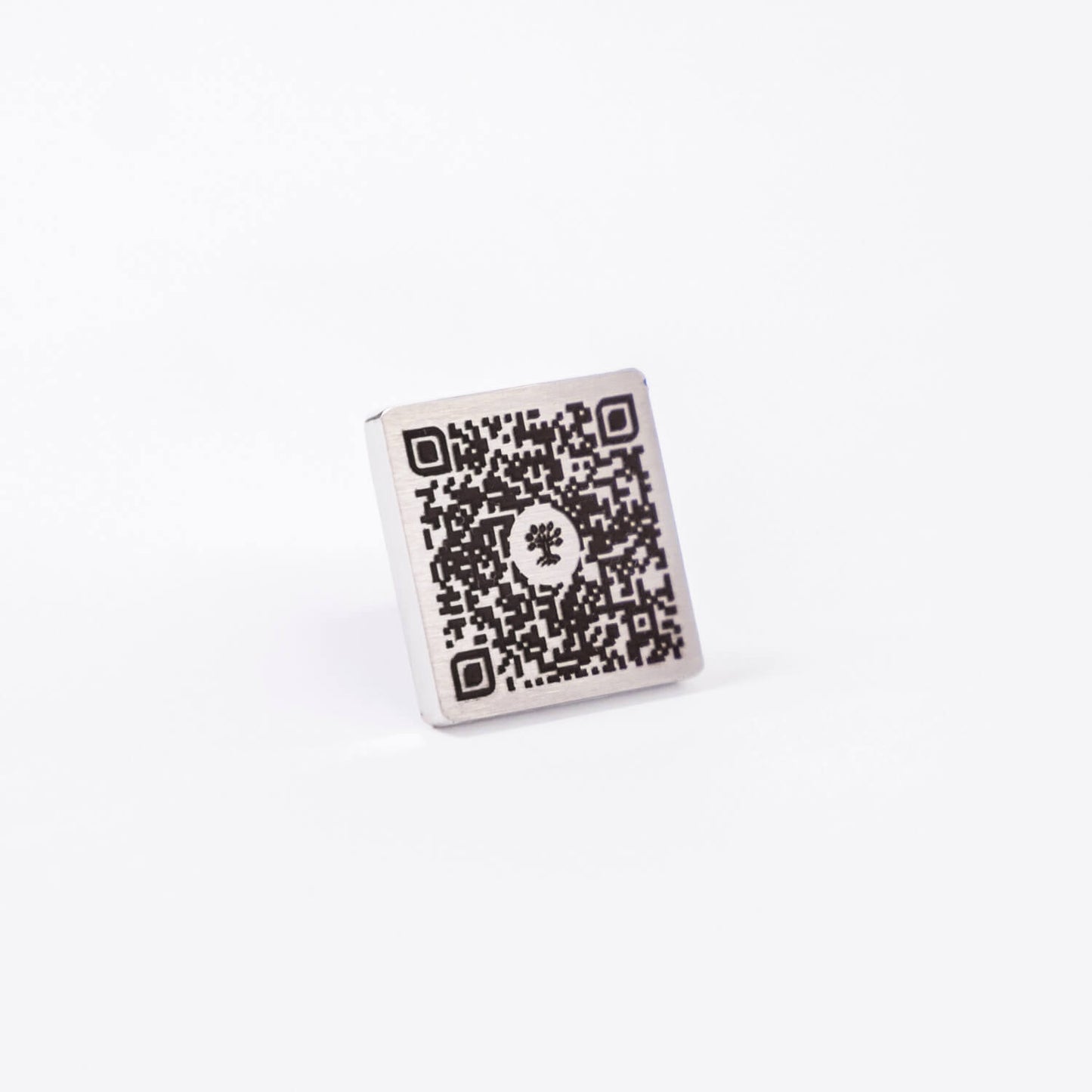 Plaque commémorative en acier inoxydable avec QR code gravé, vue en angle, permettant d’accéder à un profil hommage numérique sur la Plateforme Heritage.