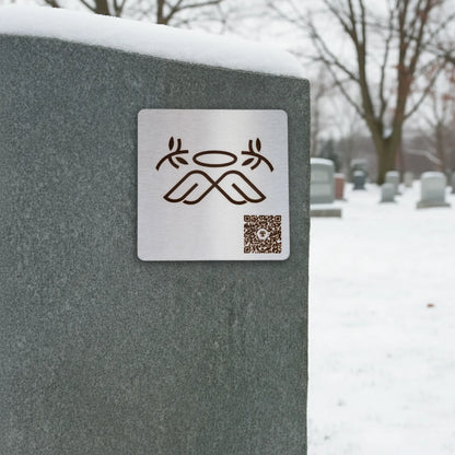 Photo de la plaque L'Ange (plaque commémorative avec un code QR), collée sur une pierre tombale.
