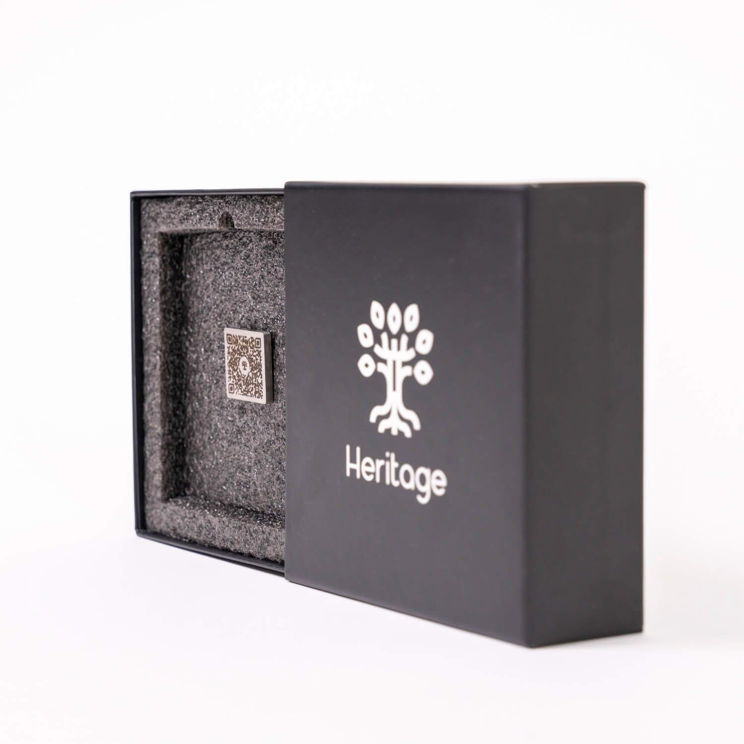 Boîte Heritage contenant une plaque commémorative 1"x1" en acier inoxydable avec code QR, protégée dans une mousse de transport sécurisée.