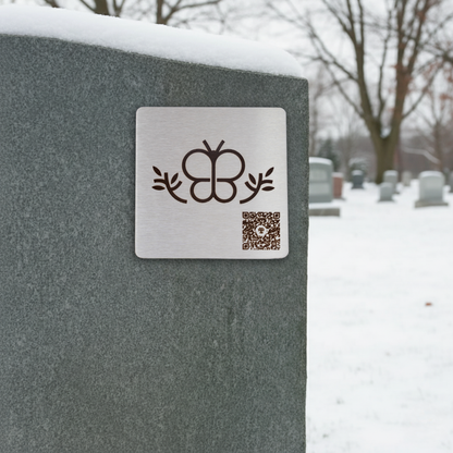 Photo de la plaque Le Papillon (plaque commémorative avec un code QR), collée sur une pierre tombale.